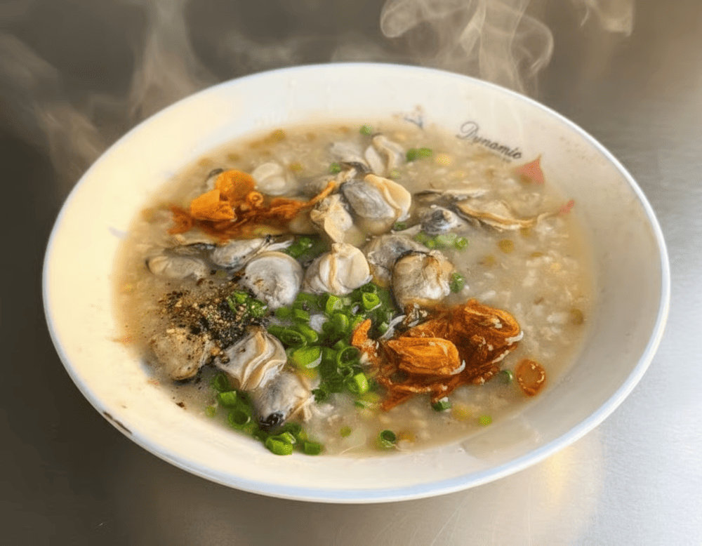 The fresh herbs, crispy shallots, and a hint of black pepper add layers of flavor, making each spoonful of clam porridge a delightful experience